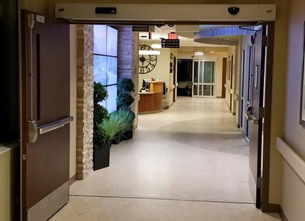 A hospital hallway with a sign that says emergency exit