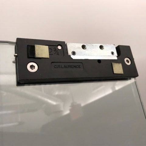 A close up of a door lock on a glass door.