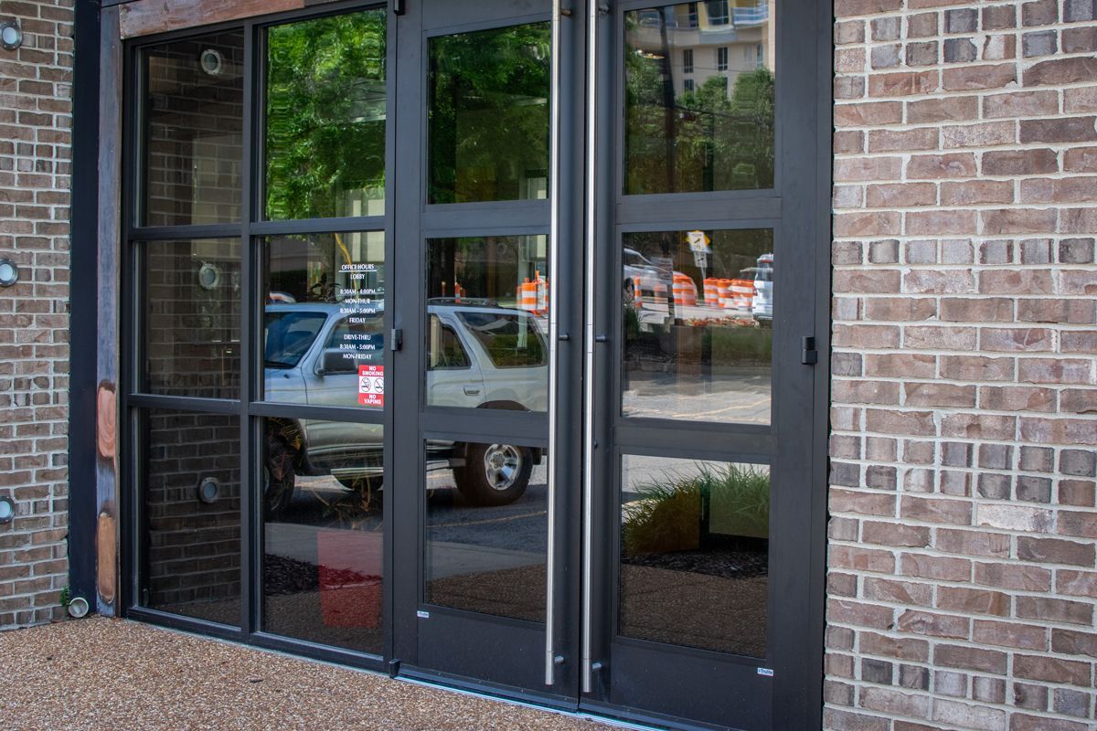 A brick building with a lot of windows and a car parked in front of it.