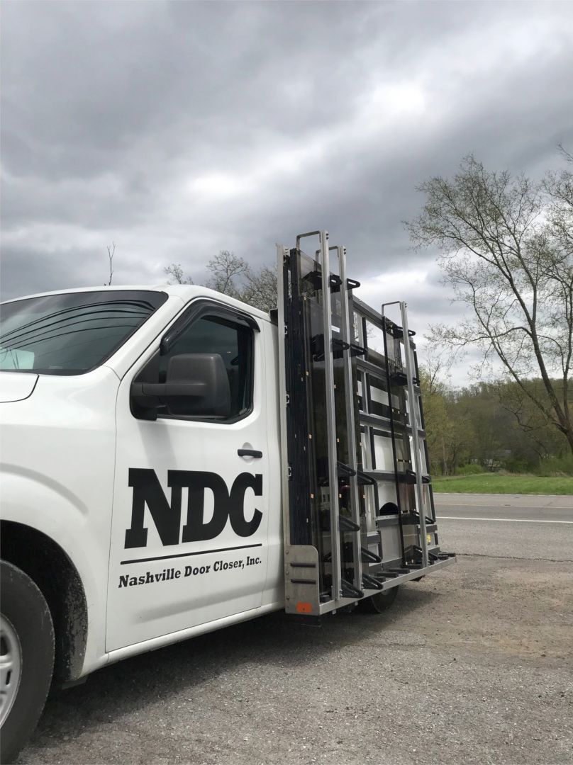 Storefronts & Glass Doors Installation and Repair - A white truck with the word ndc on the side is parked in a parking lot.