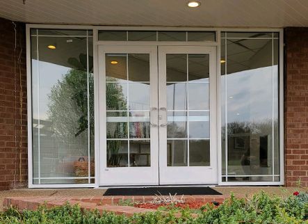 A brick building with a white door and windows