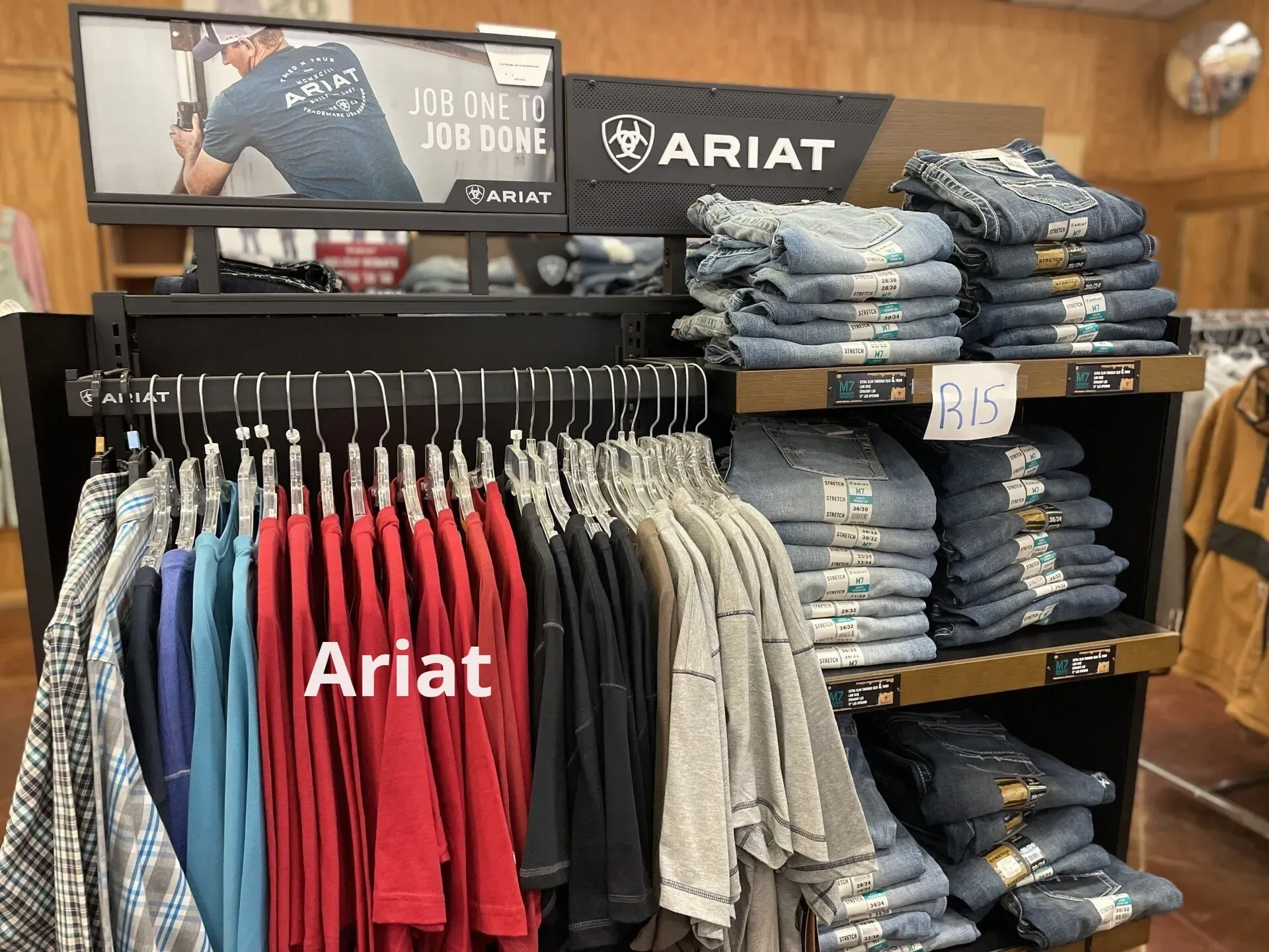 A display of ariat shirts and jeans in a store.