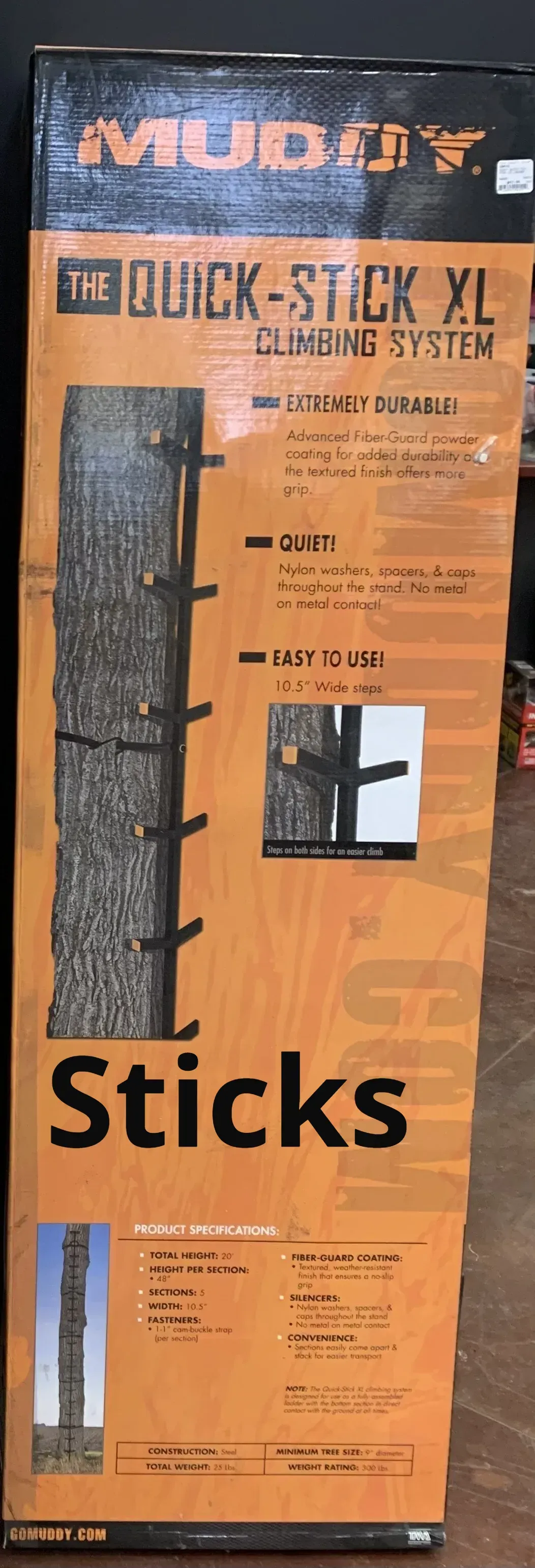 A box of sticks is sitting on a wooden floor.