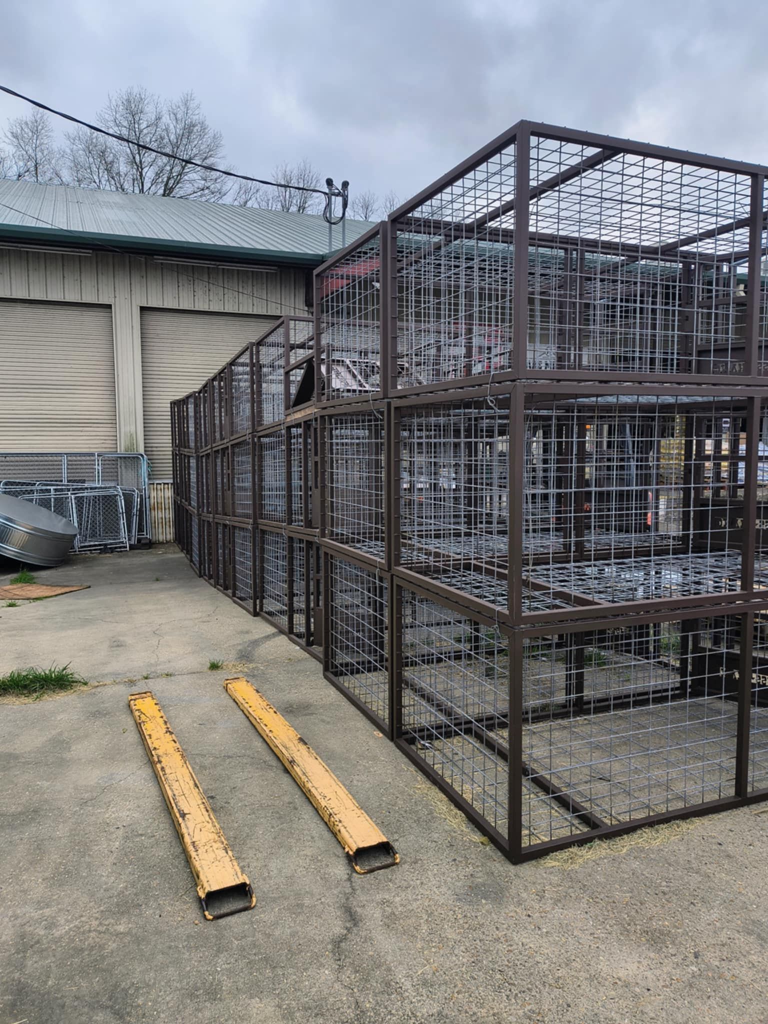 A row of metal crates are stacked on top of each other in a parking lot.