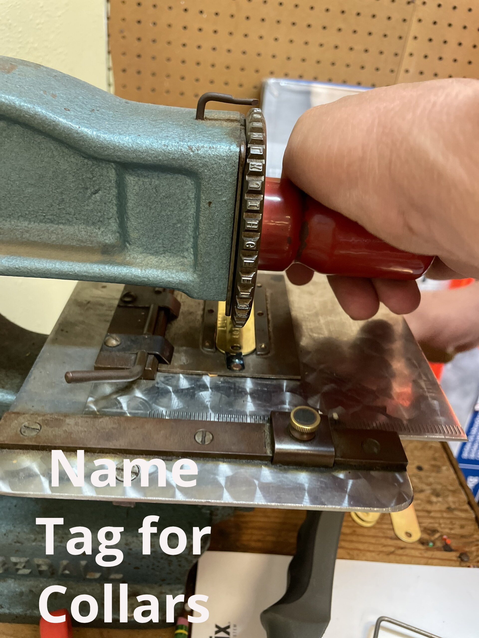 A person is using a machine to make a name tag for collars