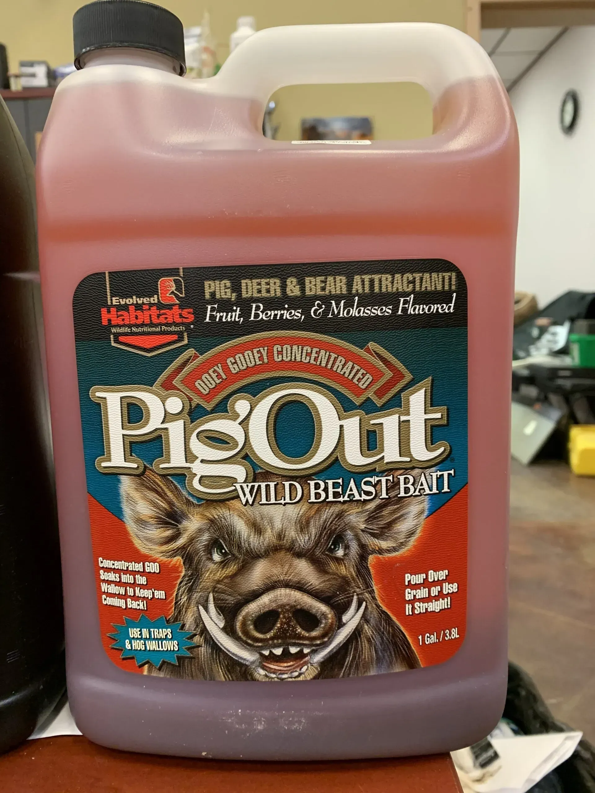 A gallon of pig out wild blast bait is sitting on a wooden table.