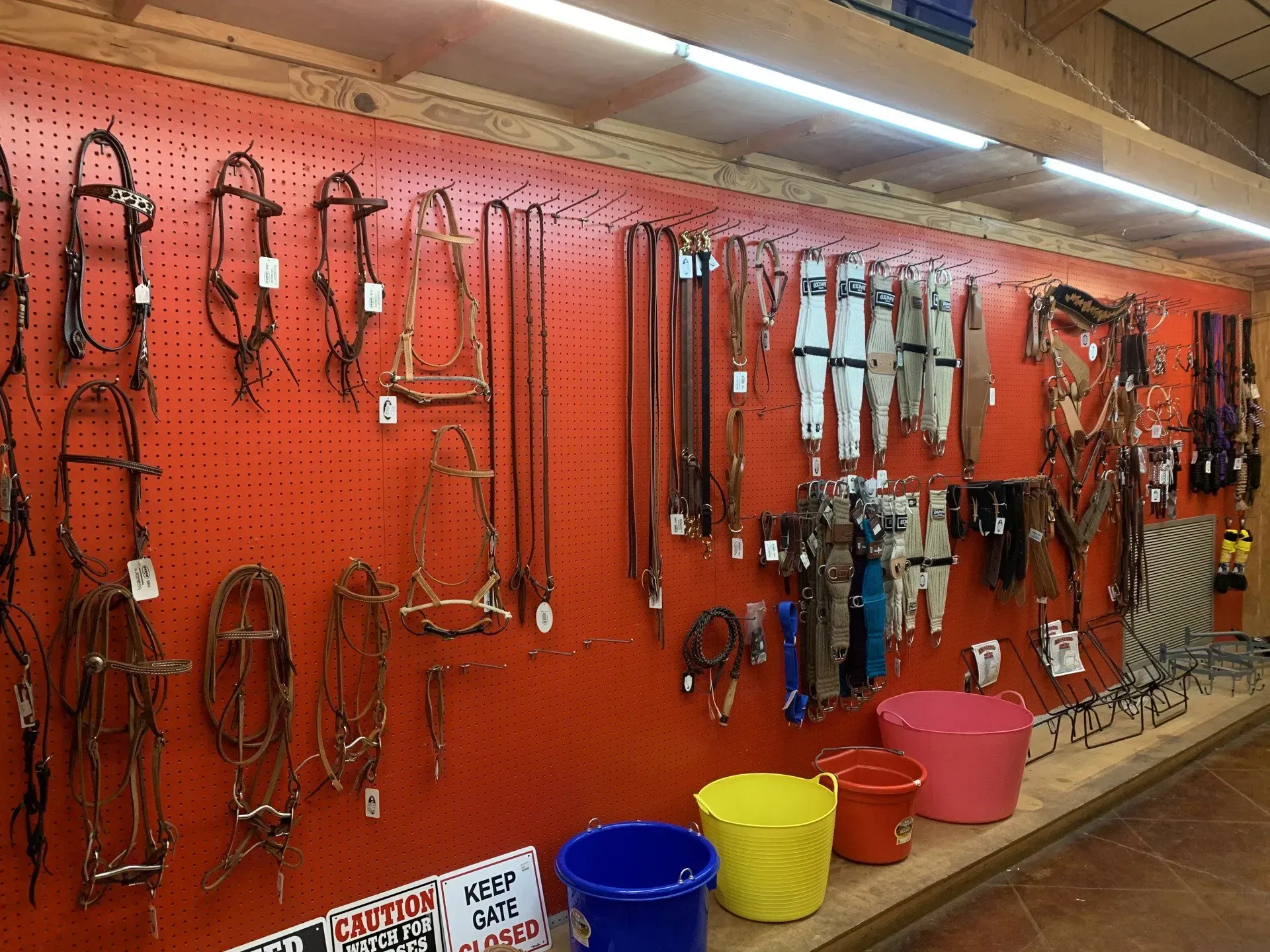 A wall with a bunch of horse equipment hanging on it