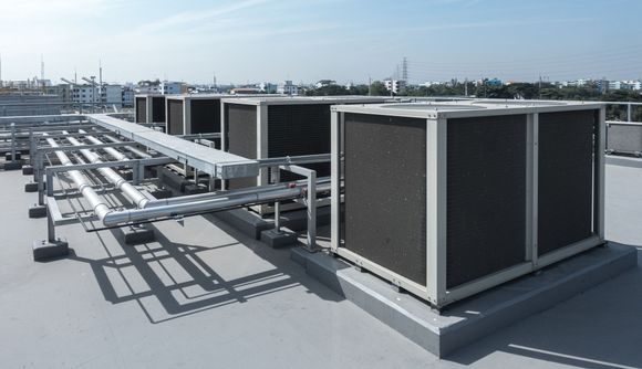 HVAC unit with gauges and hoses, likely being serviced outdoors. Sunlight.
