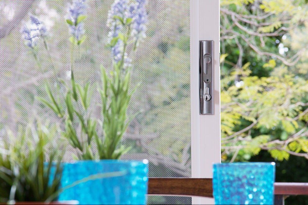 Plant In Front Of Screen Door — Glass & Aluminium Windows & Doors In Yeppoon, QLD