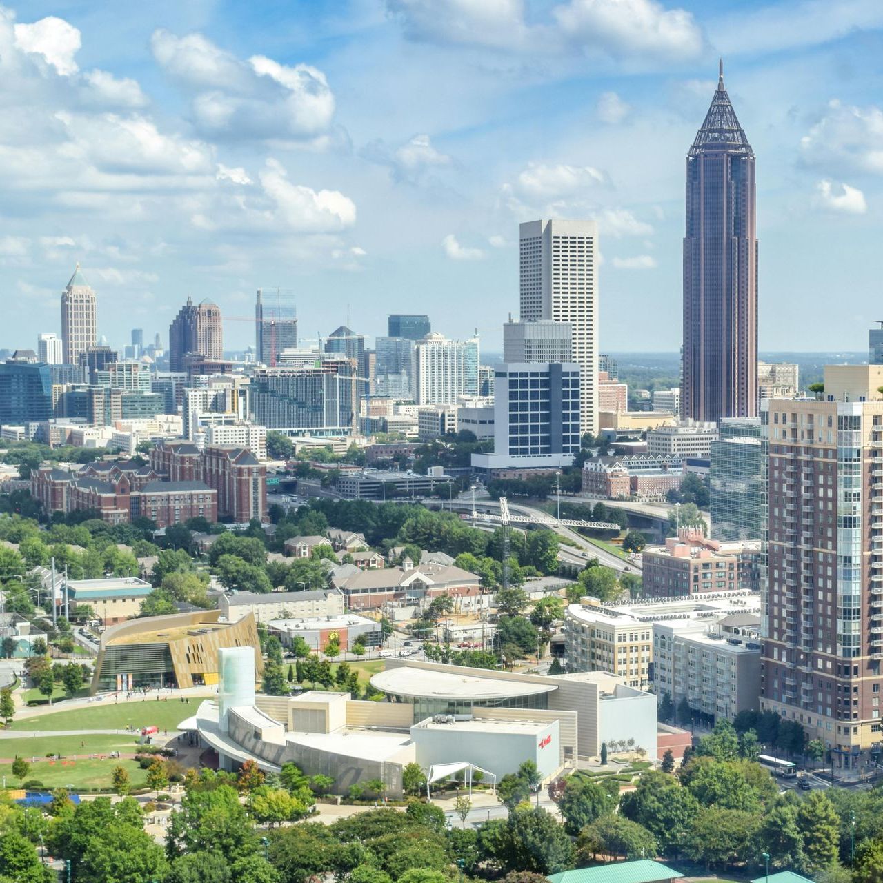 A woman is holding a child while a man looks on.