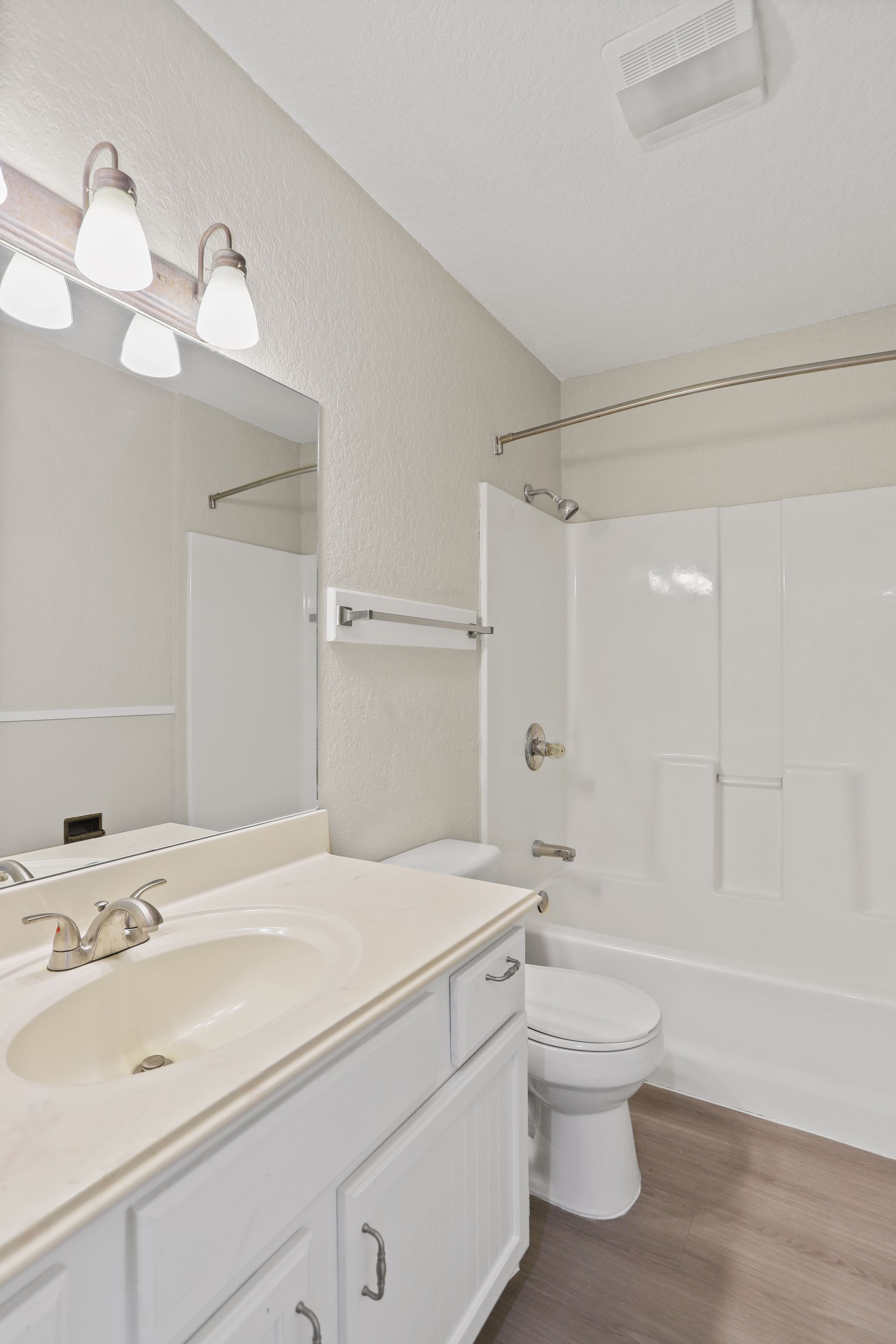Photo of a bathroom with a towel rack above the toilet and a bathtub shower combo