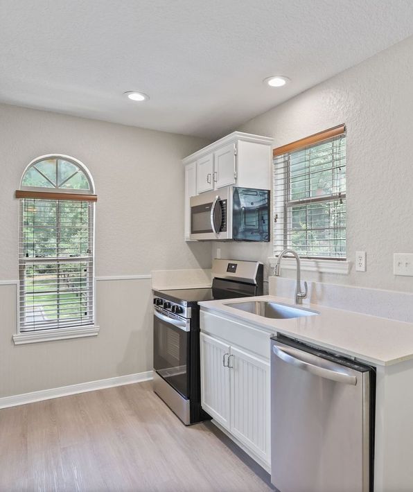 Photo showing a kitchen with appliances and plenty of natural lighting