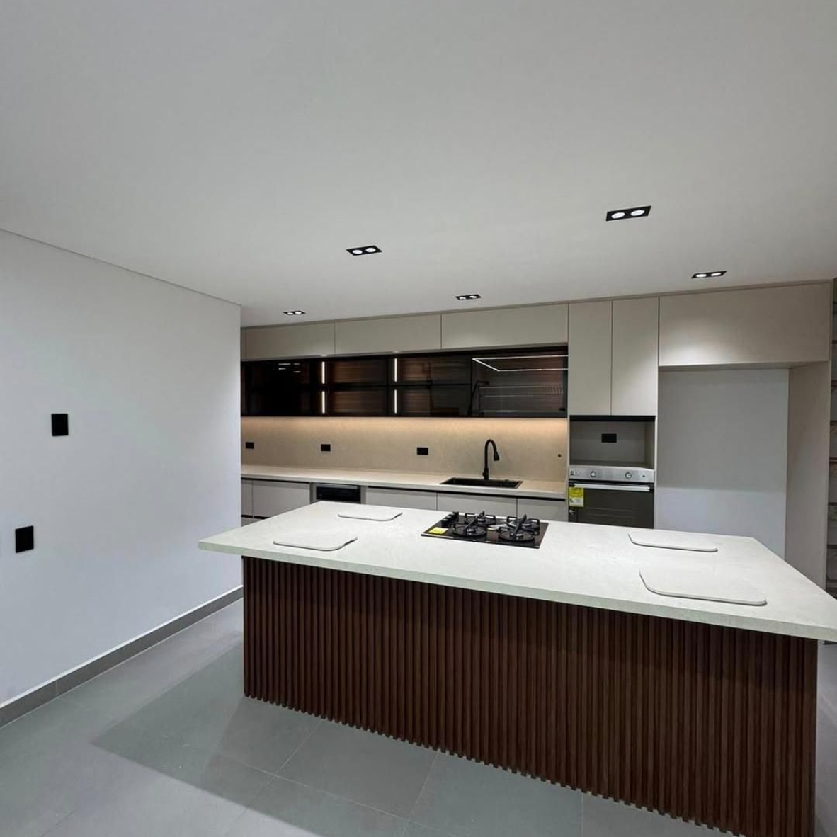 Cocina moderna con gabinetes de madera, isla de mármol, electrodomésticos
