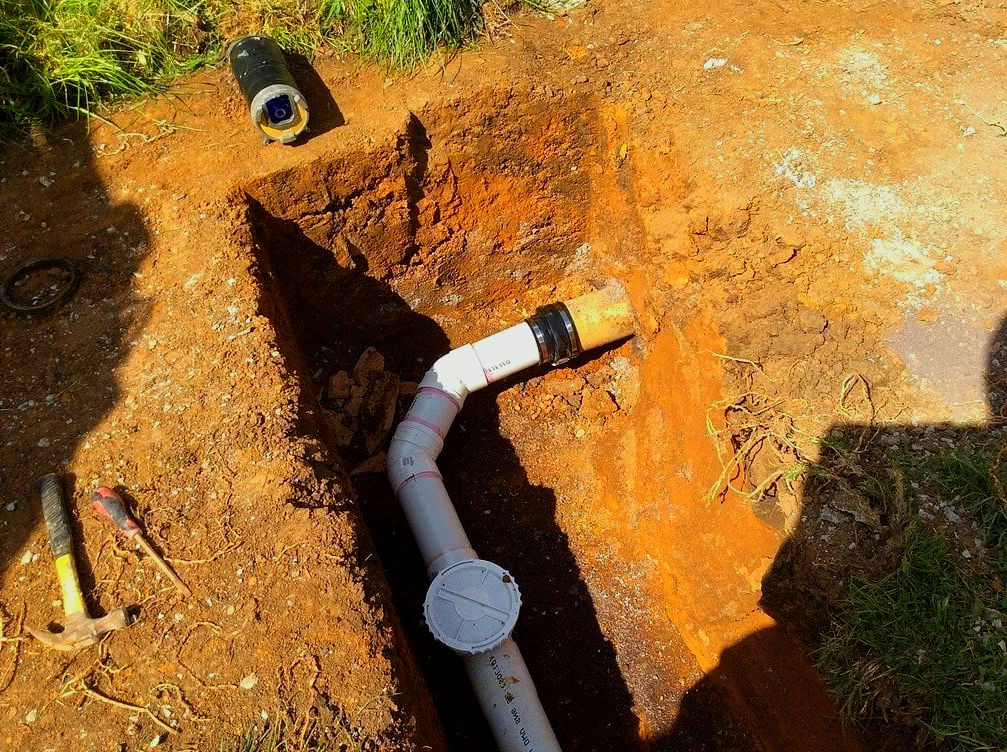 A pipe is being installed in a hole in the ground.