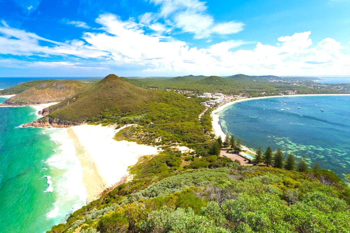 An aerial view of a beach and a body of water on a sunny day.