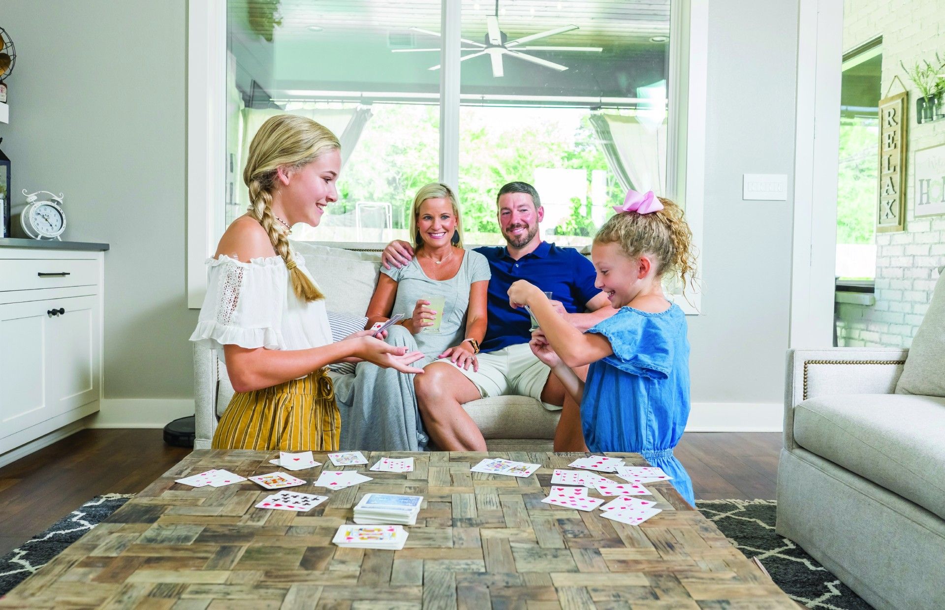 A family is playing a game of cards in a living room.