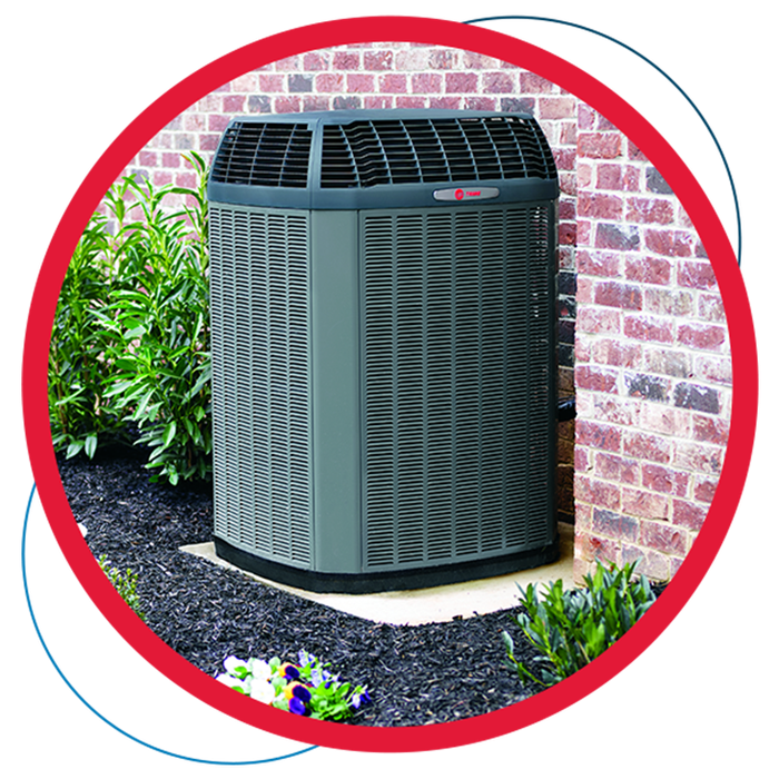 A large air conditioner is sitting outside of a brick building