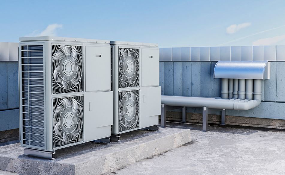 There are two air conditioners on the roof of a building.