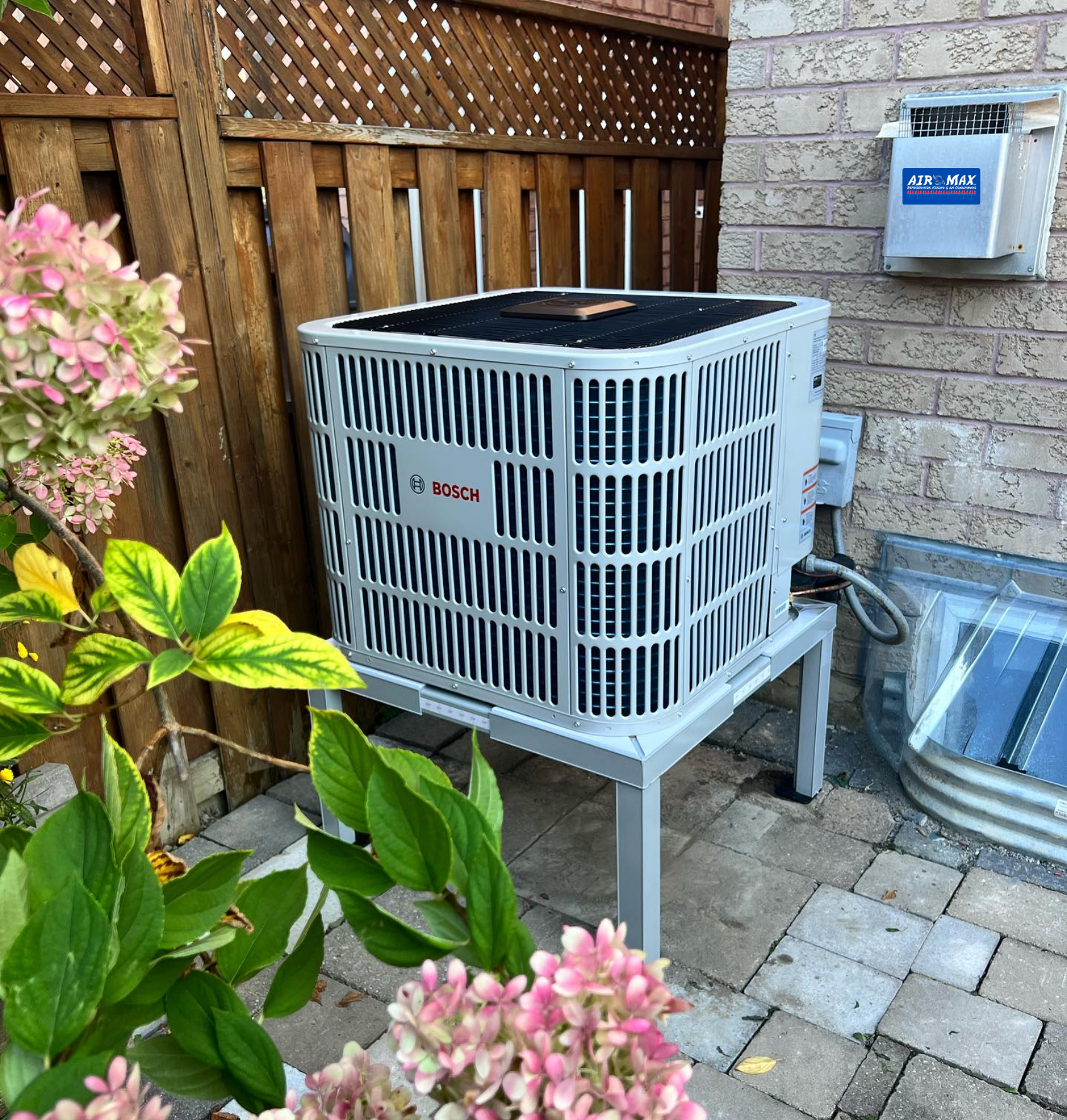 A large air conditioner is sitting on the side of a brick building.