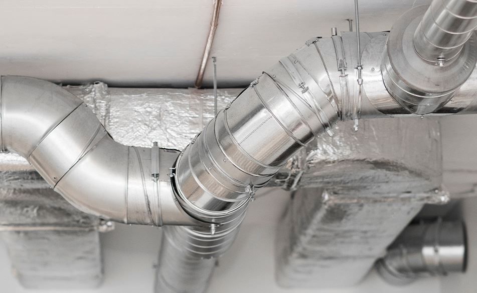A bunch of metal pipes hanging from the ceiling of a building.