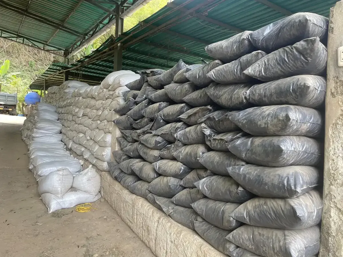 Un almacén lleno de muchas bolsas apiladas de tierra una encima de otra.