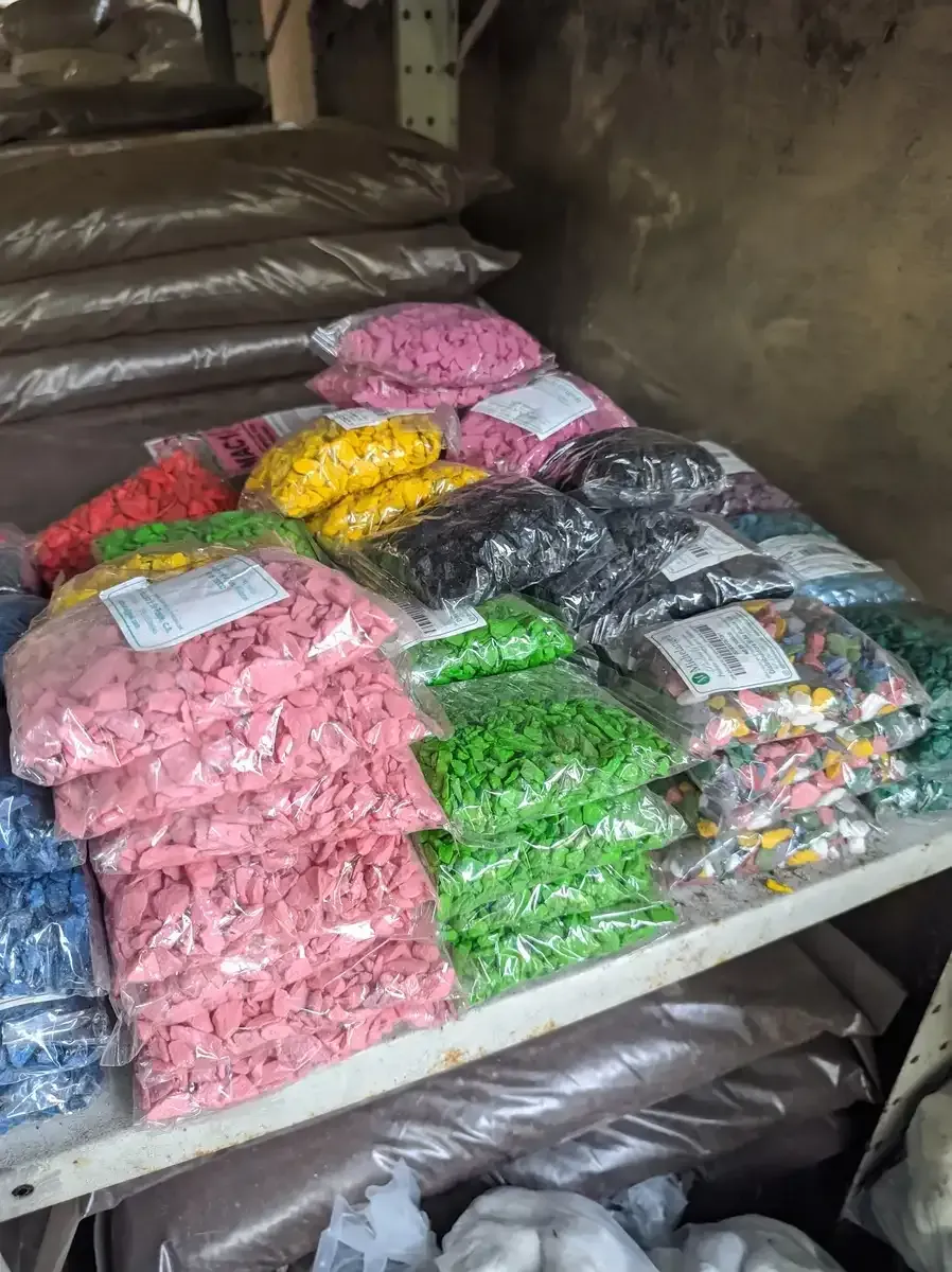 Un montón de bolsas de dulces están apiladas una encima de otra en un estante.