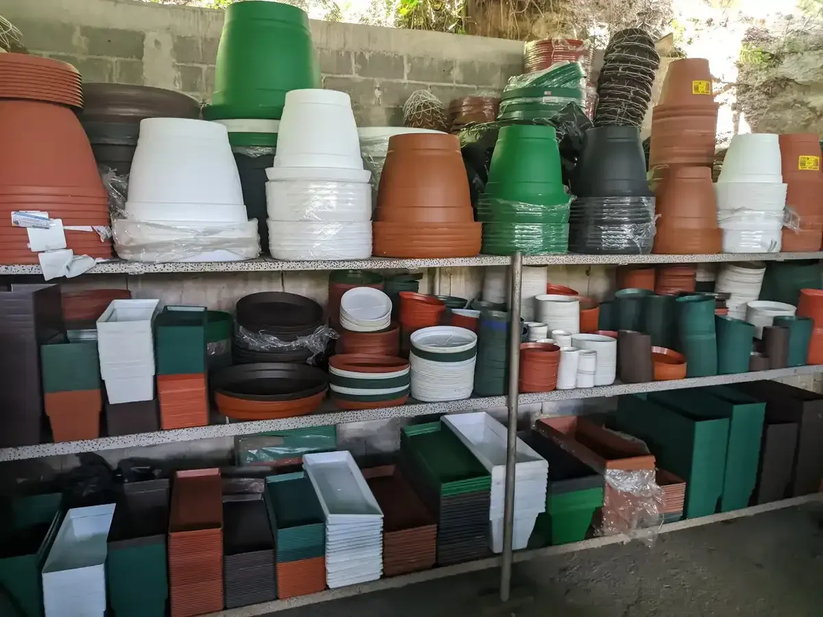 Un estante lleno de muchos tipos diferentes de macetas.