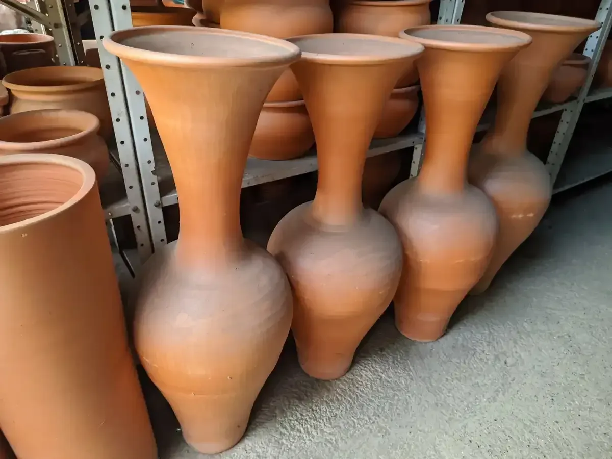 Un montón de jarrones de arcilla están alineados en fila.