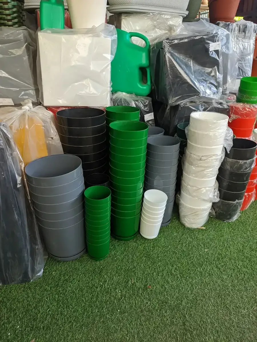 Un montón de vasos de plástico están apilados uno encima del otro sobre el césped.