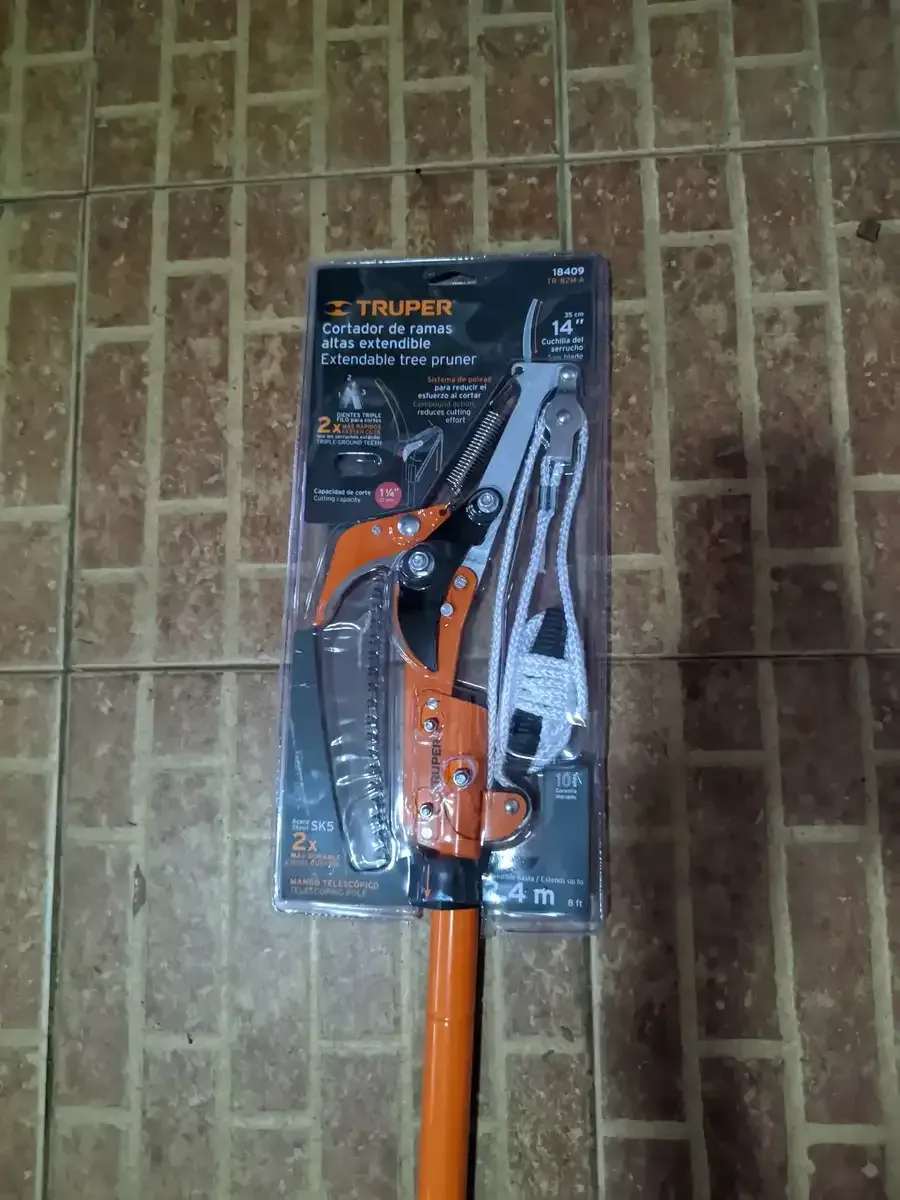 Un par de tijeras de podar colocadas sobre un suelo de baldosas.