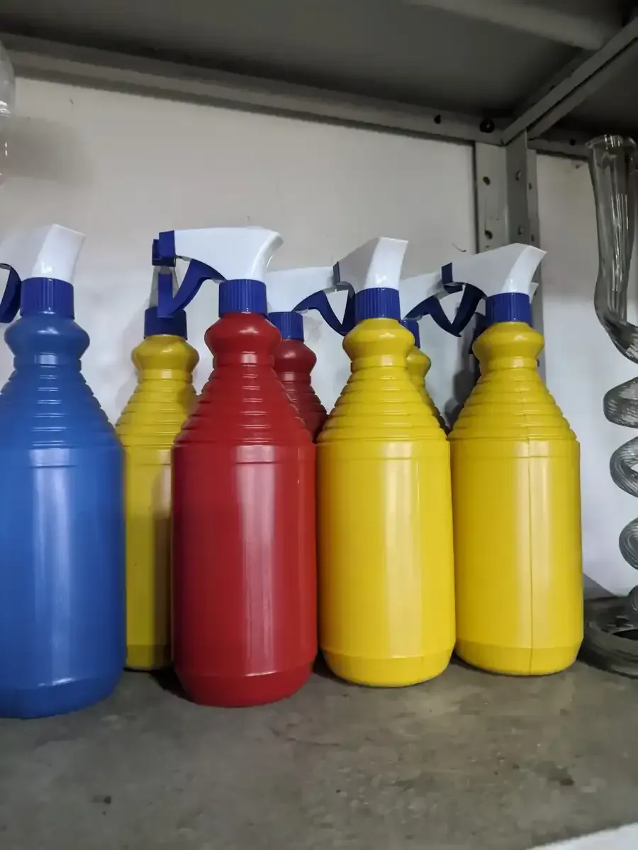 Un montón de botellas de spray están alineadas en un estante.