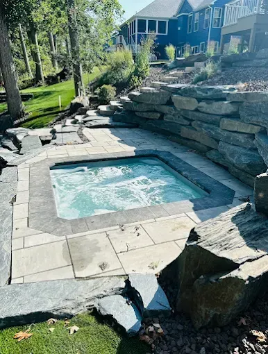 Flagged home entrance with brick pathway and manicured landscape.