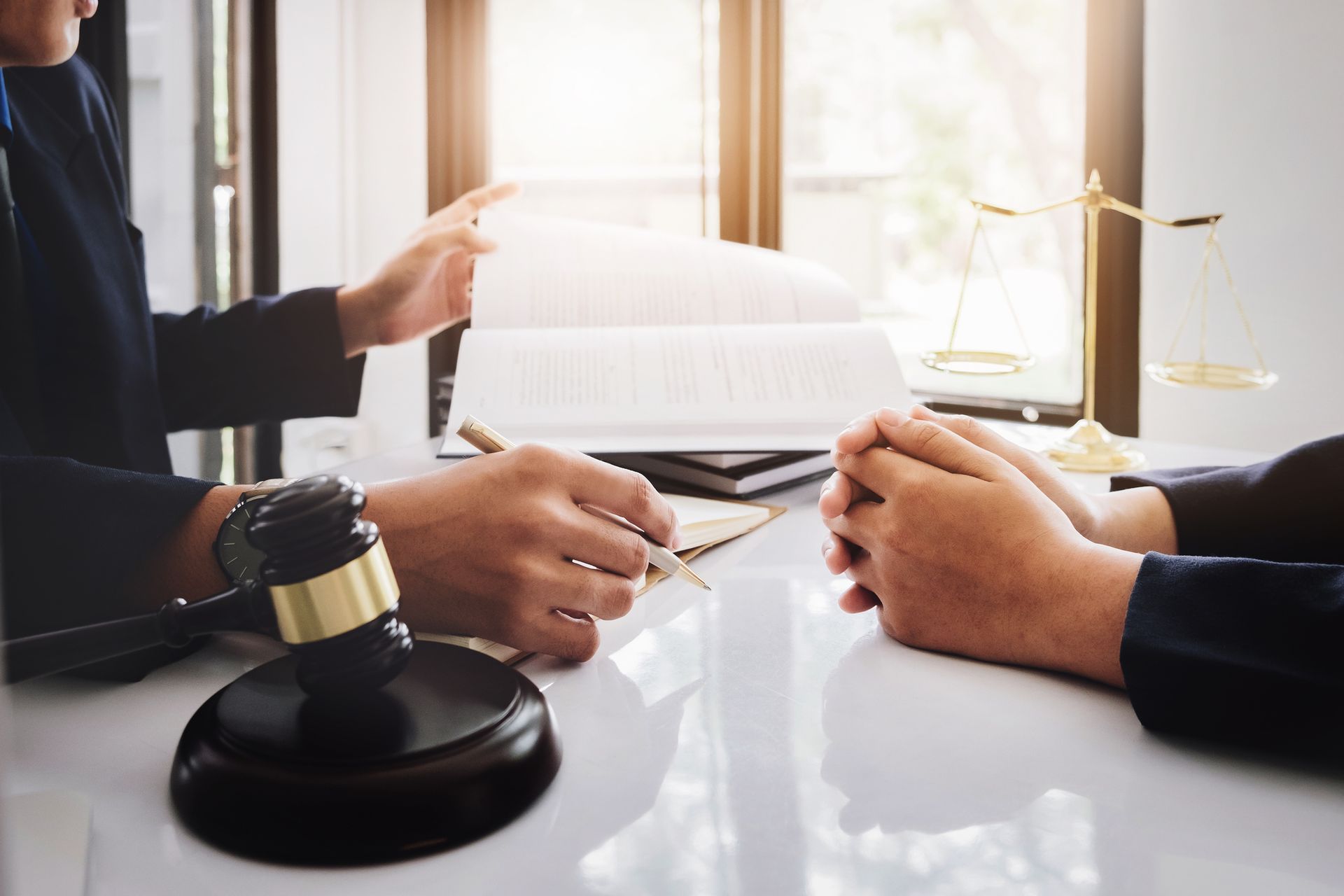 Bankruptcy lawyer discussing legal options with client beside gavel in law office setting. Bankruptcy lawyer discussing legal options with client beside gavel in law office setting.