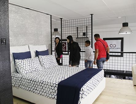 un gruppo di persone sta guardando un letto in una camera da letto .