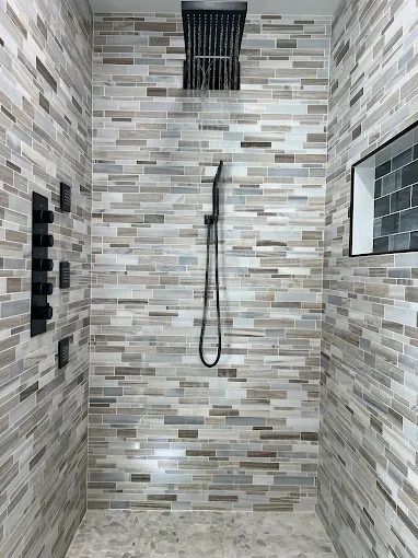 Construction site with PVC pipes and blue/red water lines in a trench next to cinder blocks and wooden framing.
