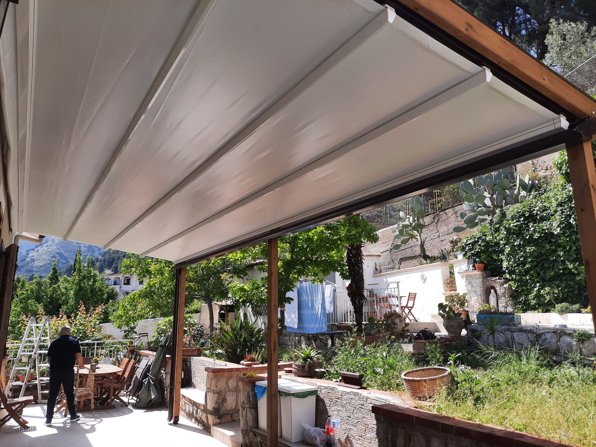 Tenda da sole bianca retrattile sopra un patio. 