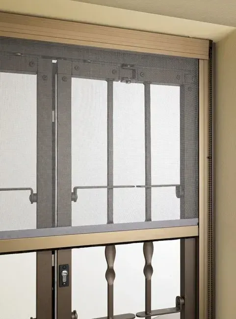 Finestra con zanzariera retrattile, telaio in bronzo, chiusa. Ambientazione interna.