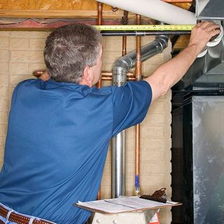 Plumber measuring the pipe — Plumbing & Heating Contractors in Newton, MA