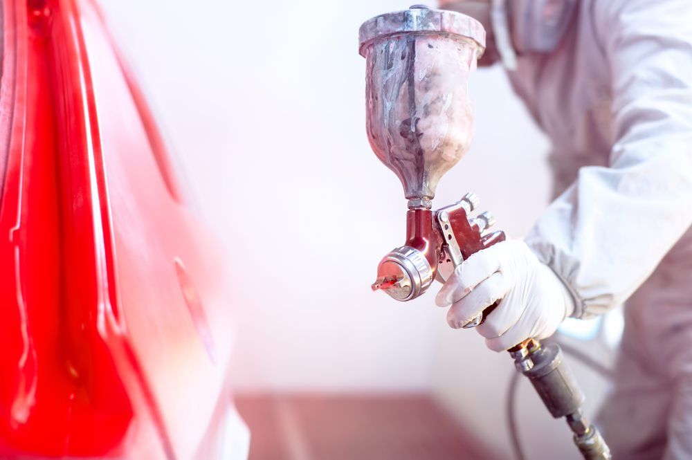 Close-Up Of Spray Gun With Red Paint — Panel Beater In Goondi, QLD