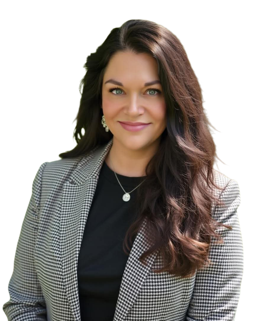 A woman is sitting at a desk with a laptop and a vase of flowers.