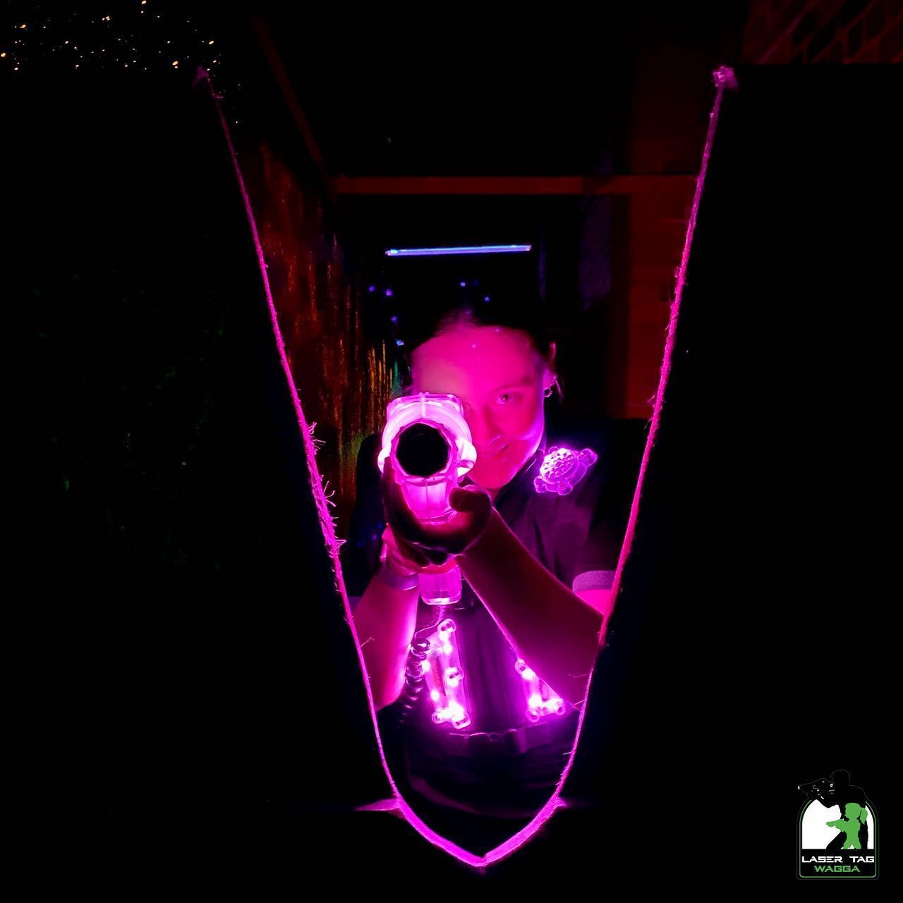 A girl pointing a laser gun in a dark room— Laser Tag Wagga In Wagga Wagga, NSW