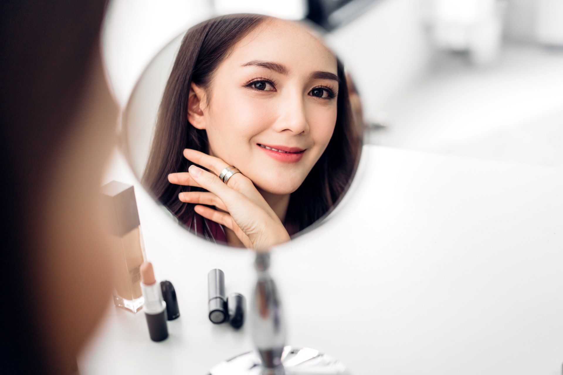Una donna si guarda il viso allo specchio.