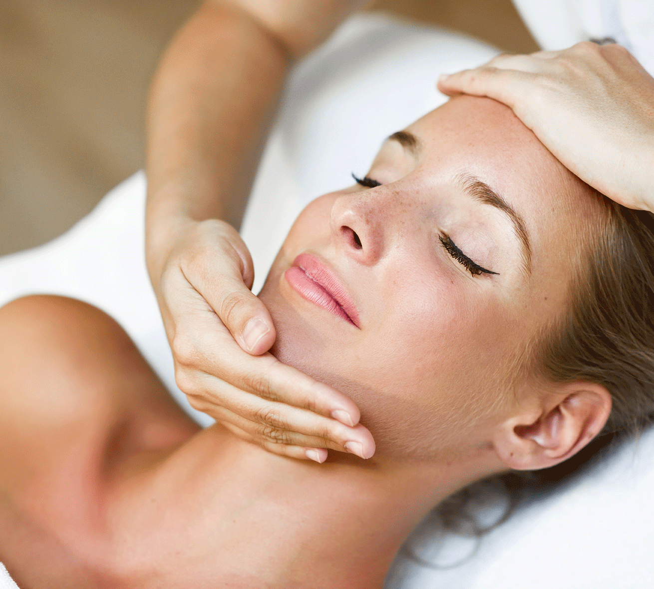 Una donna riceve un massaggio facciale con gli occhi chiusi