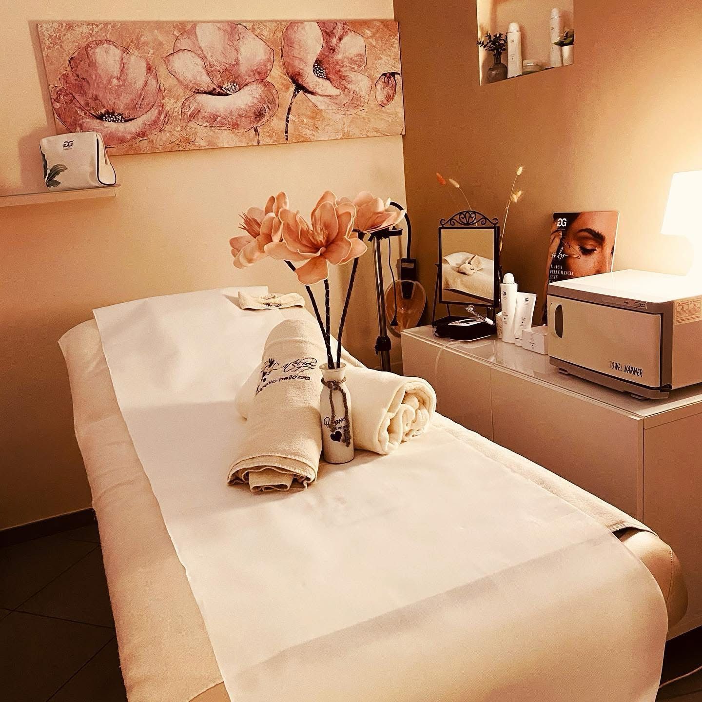 Un lettino da massaggio con asciugamani e fiori sopra