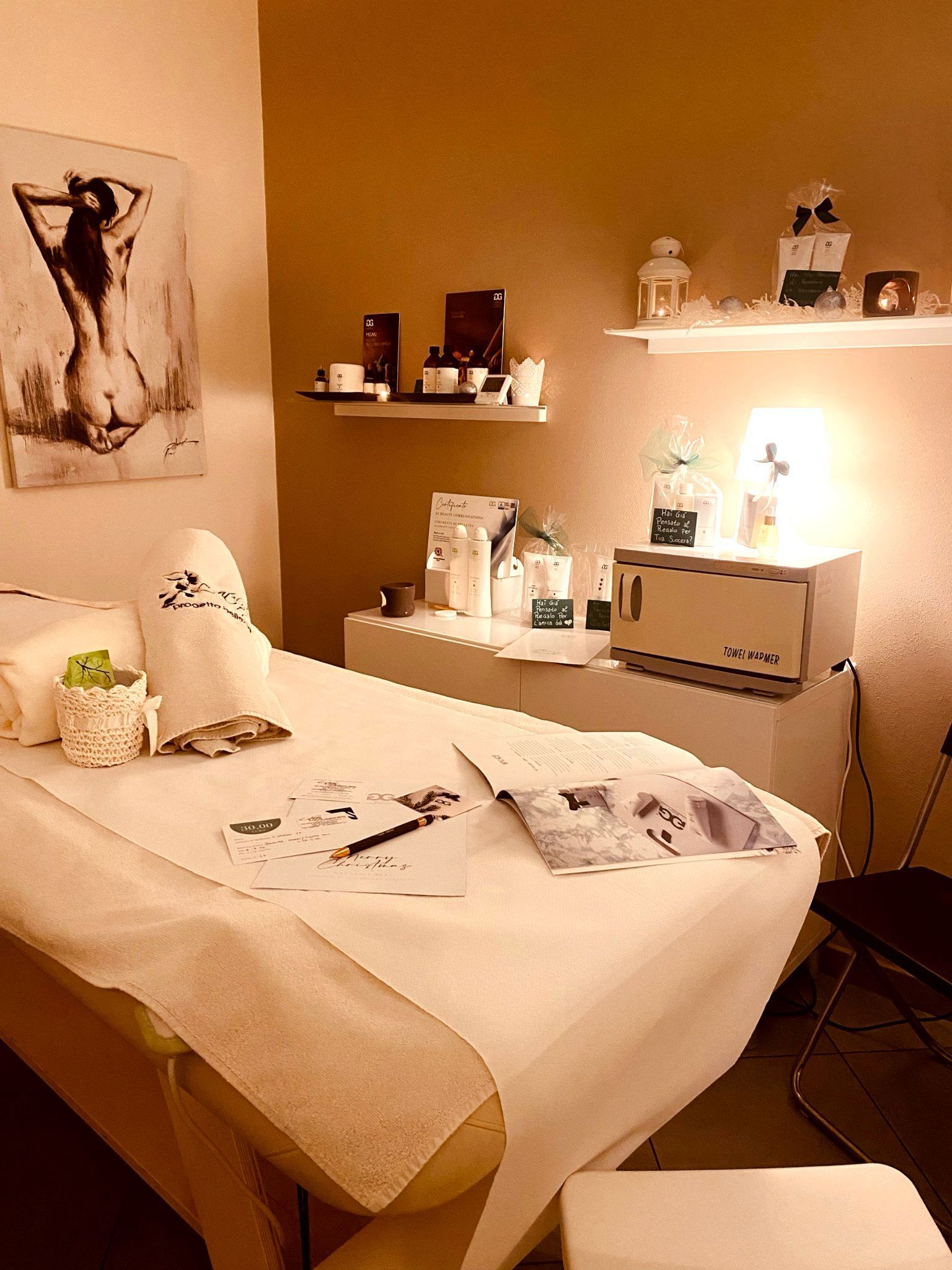 Un lettino per massaggi in una stanza con la foto di una donna sulla parete.