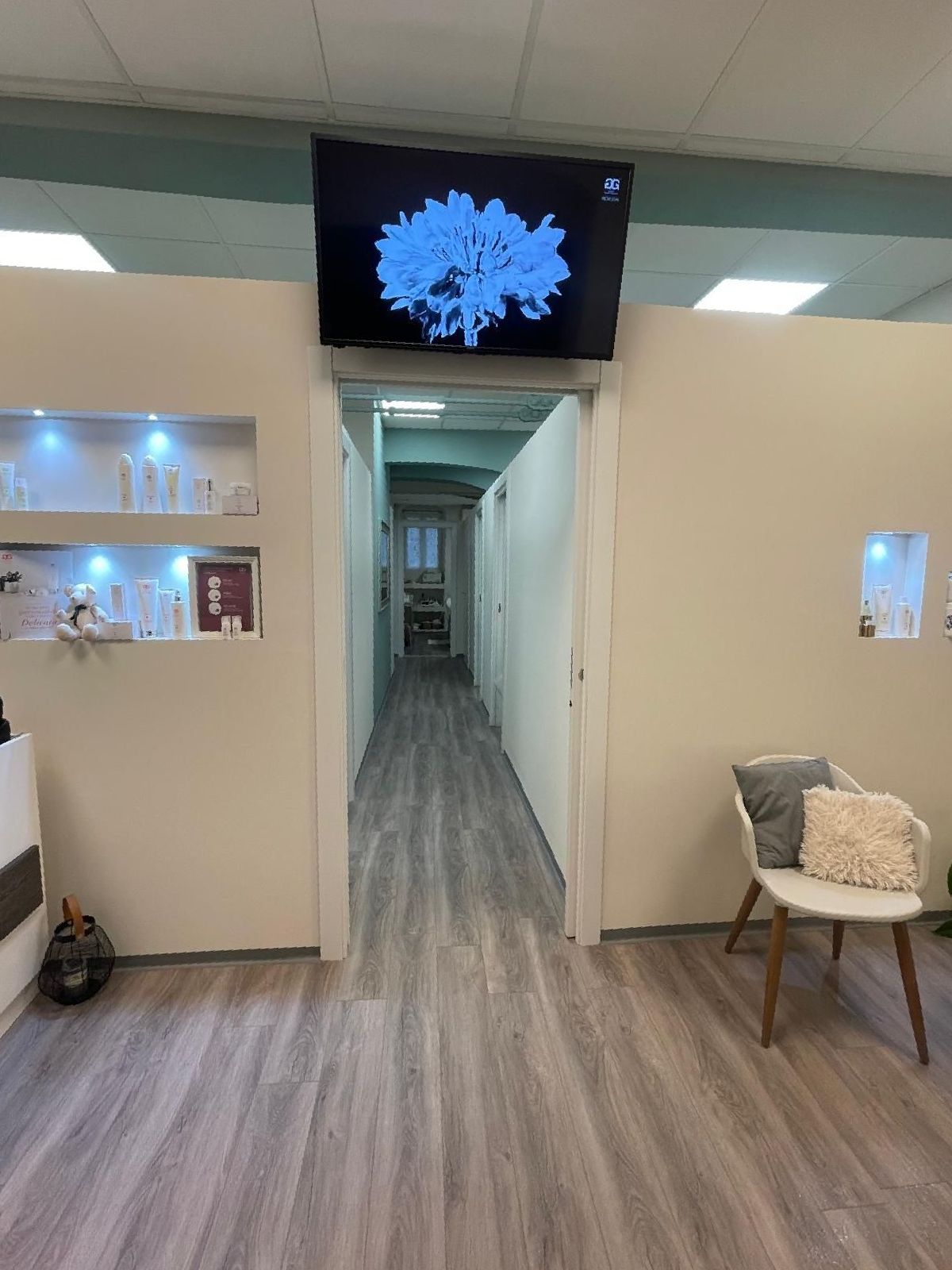 Un lungo corridoio con una sedia e una televisione sul soffitto.