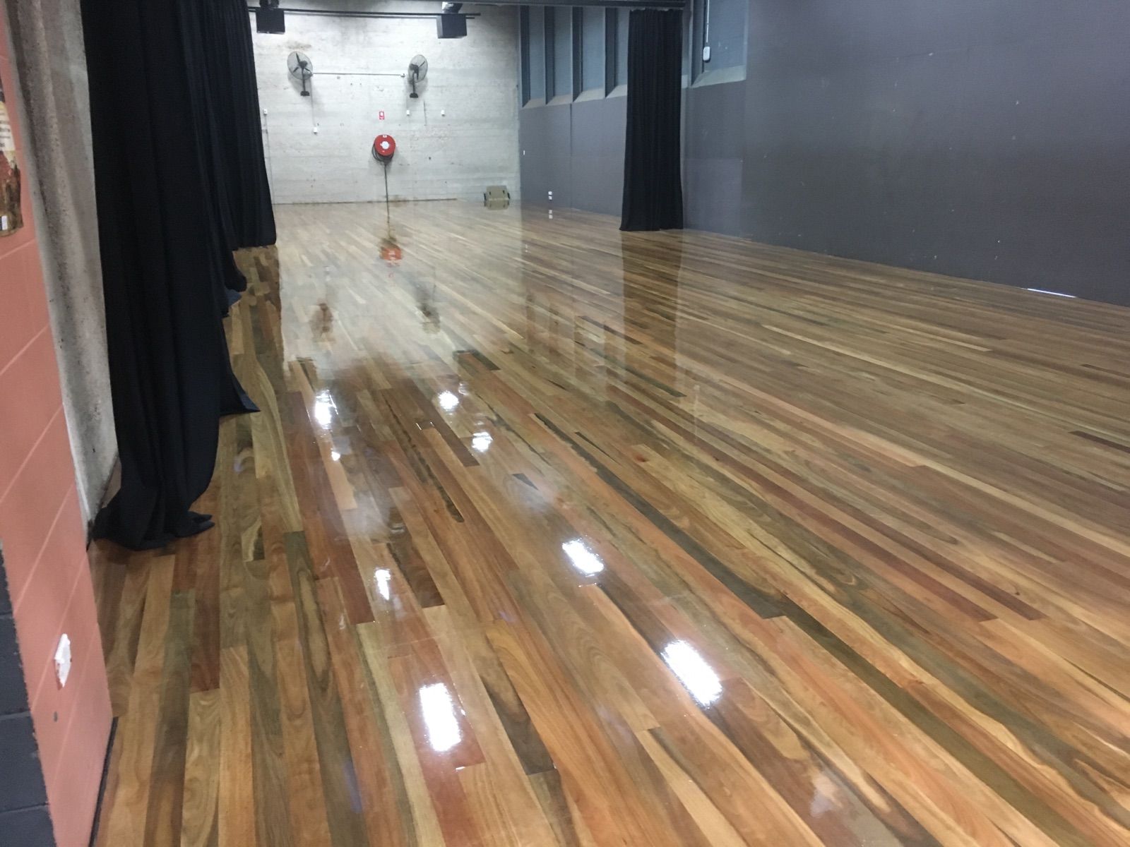 Wooden dance floor in a studio with black curtains, grey and white walls — AKW Builders Pty Ltd In Leanyer, NT