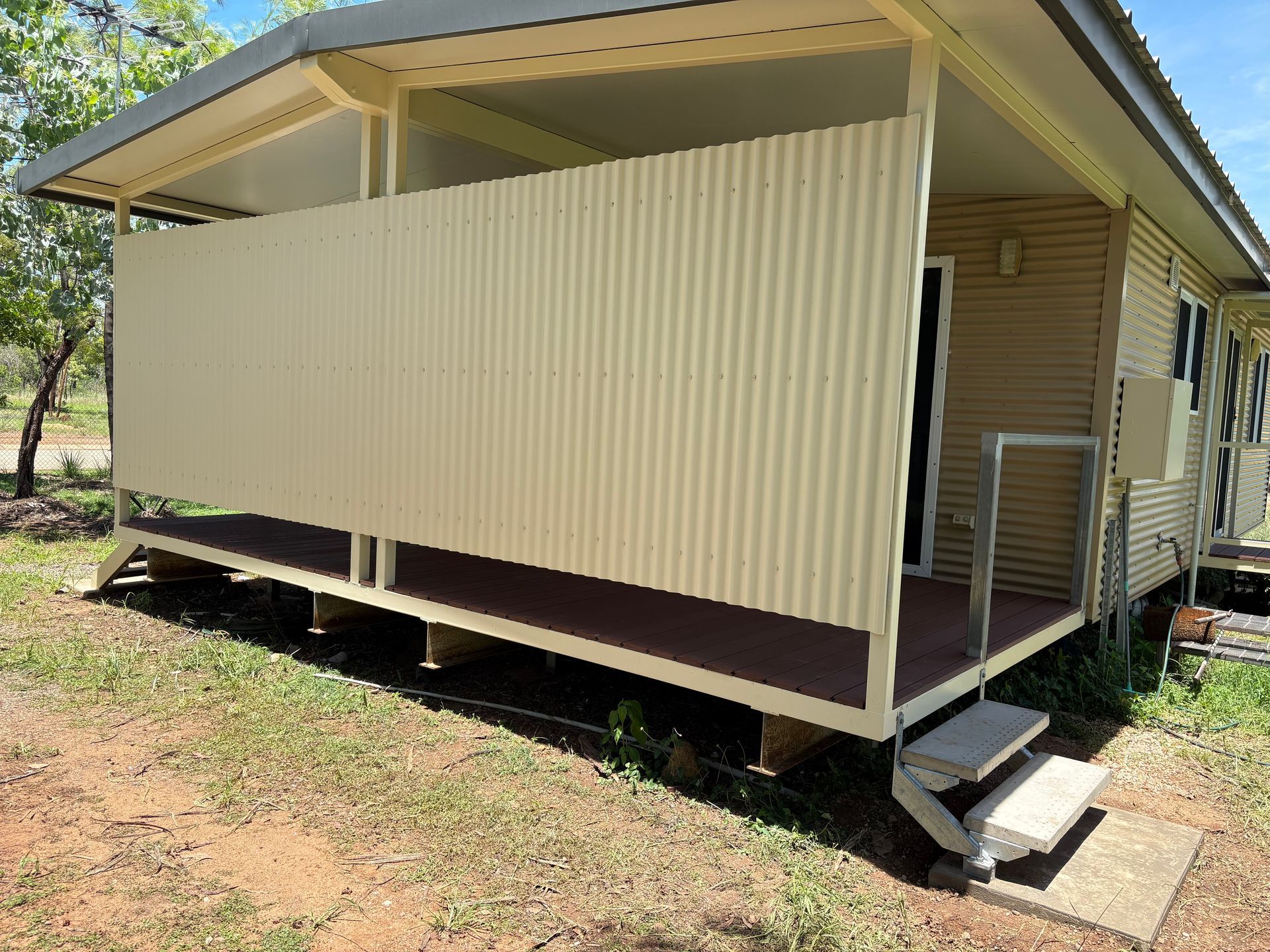 Beige corrugated metal privacy screen on a porch with stairs — AKW Builders Pty Ltd In Leanyer, NT