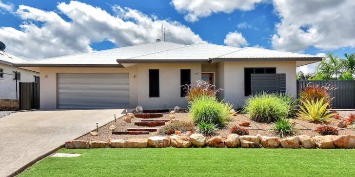 A single-story beige house with a driveway, steps, and landscaping under a blue sky with clouds — AKW Builders Pty Ltd In Leanyer, NT