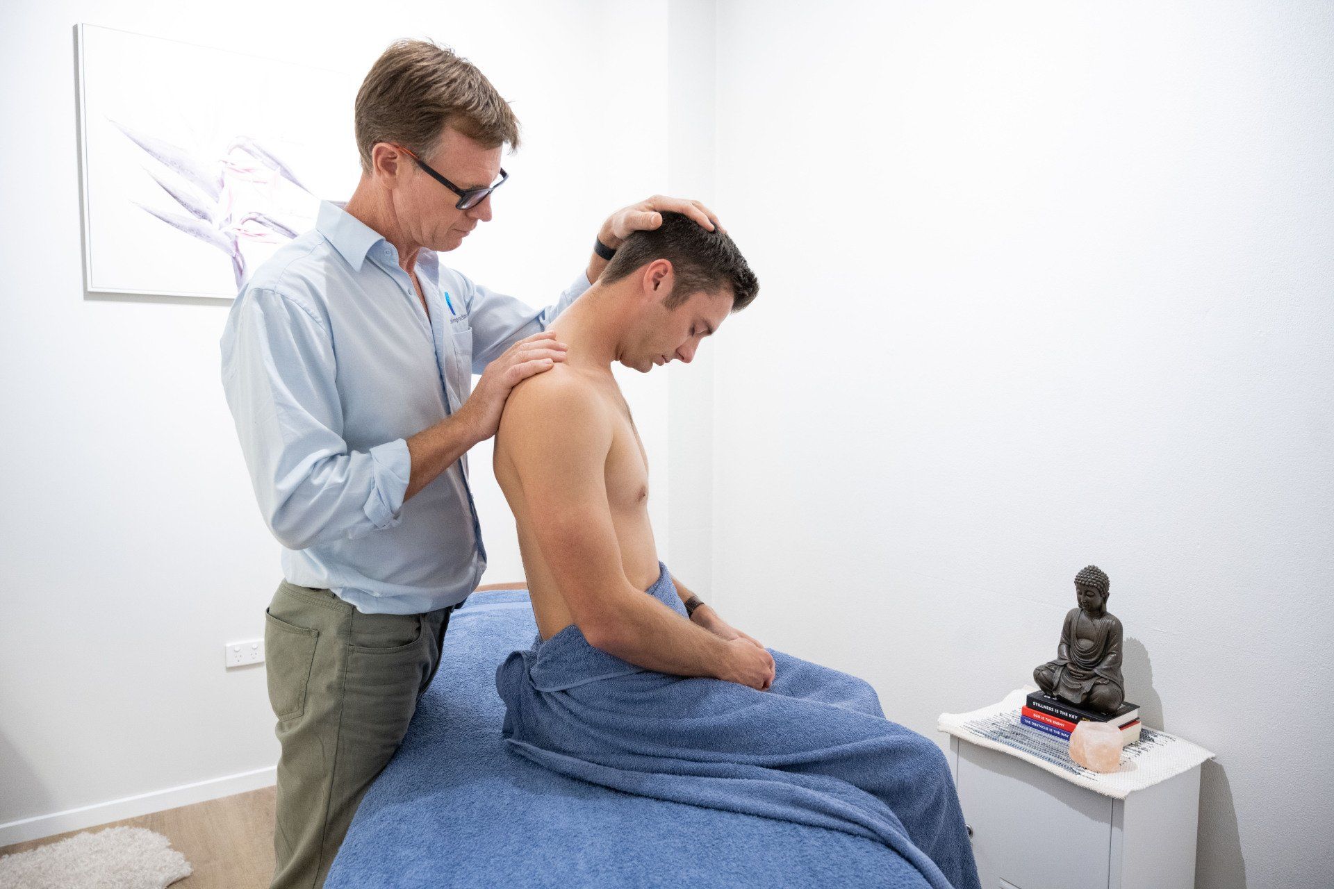 man during his first chiropractic appointment having his back assessed in Mackay
